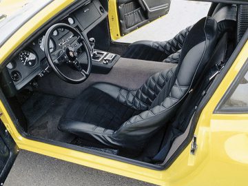Het interieur van een gele Ligier 911.