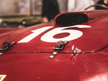 Een rode Ferrari sportwagen met het nummer 16 erop, deelnemend aan de Mille Miglia 2019.