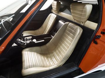 Het interieur van een Miura-sportwagen met lederen stoelen.