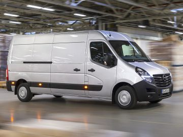Een Opel Movano-busje rijdt door een magazijn.