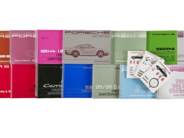 Een verzameling Porsche onderhoudsboekjes in verschillende kleuren.