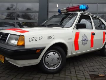 Een rijkspolitieauto met een blauw en rood licht erop.