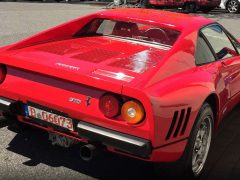Een rode Ferrari-sportwagen geparkeerd aan de kant van de weg.