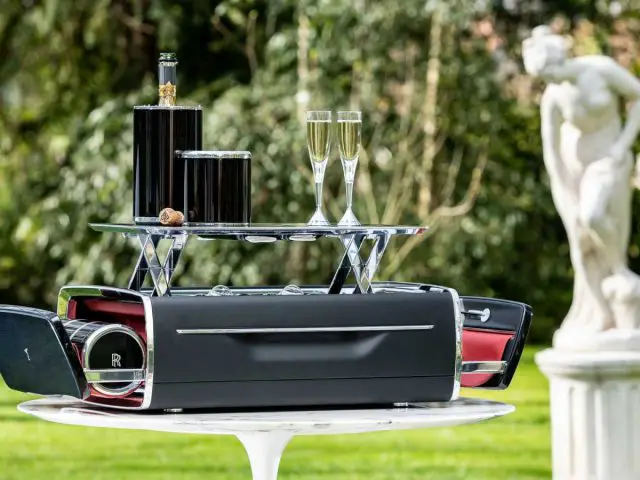 Een wijnkoeler van het merk Rolls-Royce op een tafel in een tuin.