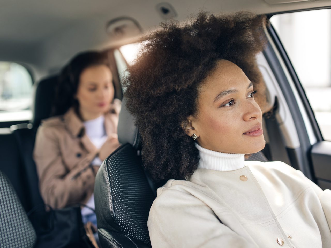 Twee vrouwen zitten op de achterbank van een Uber.