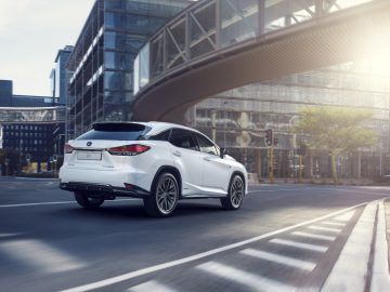 De Lexus RX 450h SUV uit 2019 rijdt door een stadsstraat.