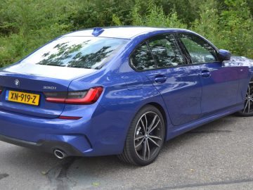 De achterkant van een blauwe BMW 3 Serie sedan.