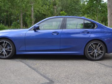 De blauwe BMW 3 Serie sedan staat geparkeerd op een parkeerplaats.