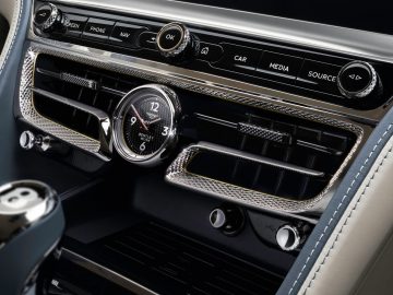 Het interieur van een Bentley met stuur en bedieningselementen.