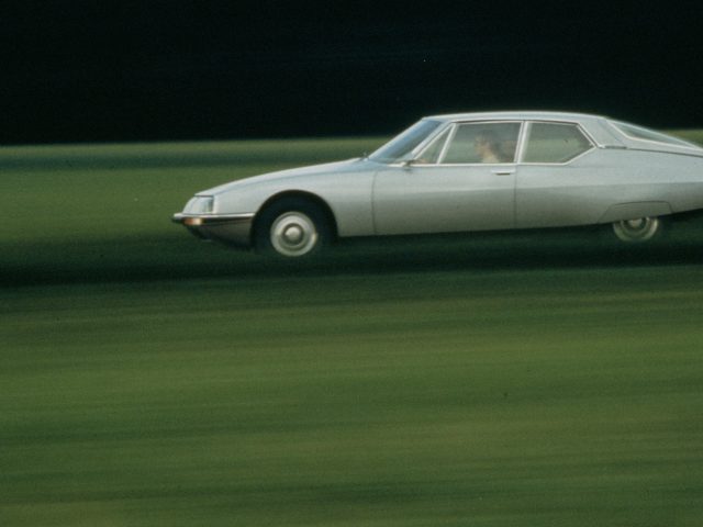 Citroën SM - een auto die door een veld rijdt.