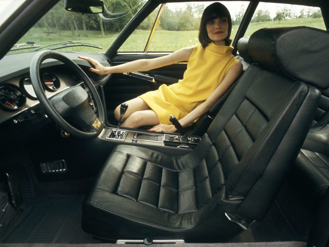 Een vrouw zittend in een Citroën SM.