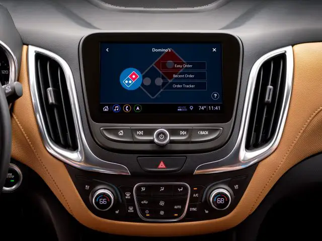 Het dashboard van een auto met het Domino's-logo erop.