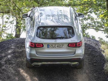 De Mercedes-Benz GLC rijdt over een onverharde weg.