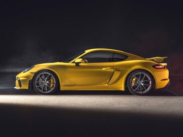 De nieuwe Porsche 718 Cayman GTS wordt getoond in een donkere kamer.