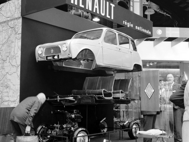 Een oude zwart-witfoto van een Renault-auto tentoongesteld.