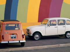 Twee Renault-auto's geparkeerd voor een kleurrijke muur.