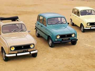 Drie kleine Renault-auto's geparkeerd op een onverharde weg.