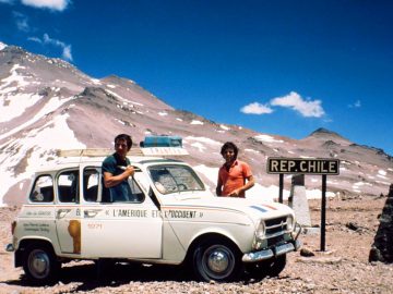 Twee mensen staan naast een Renault-auto voor een berg.