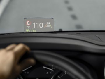 Een persoon bestuurt een Opel Zafira Life met een gps-apparaat op het dashboard.