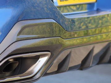 Een close-up van een blauwe BMW-auto met uitlaatpijpen.