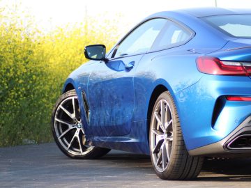 De achterkant van een blauwe BMW M8.