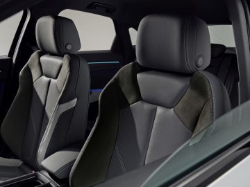 Het interieur van een Audi Q3 Sportback met zwart lederen stoelen.