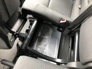 Een stoel in een Nissan NV300 met een elektronisch apparaat erin.