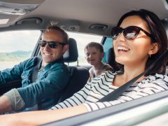 Een gezin rijdt met een zonnebril op in een auto en uit irritaties.