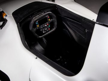 Een witte BAC Mono R racewagen met stuur.