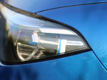 Een close-up van de koplamp van een blauwe BMW-auto.