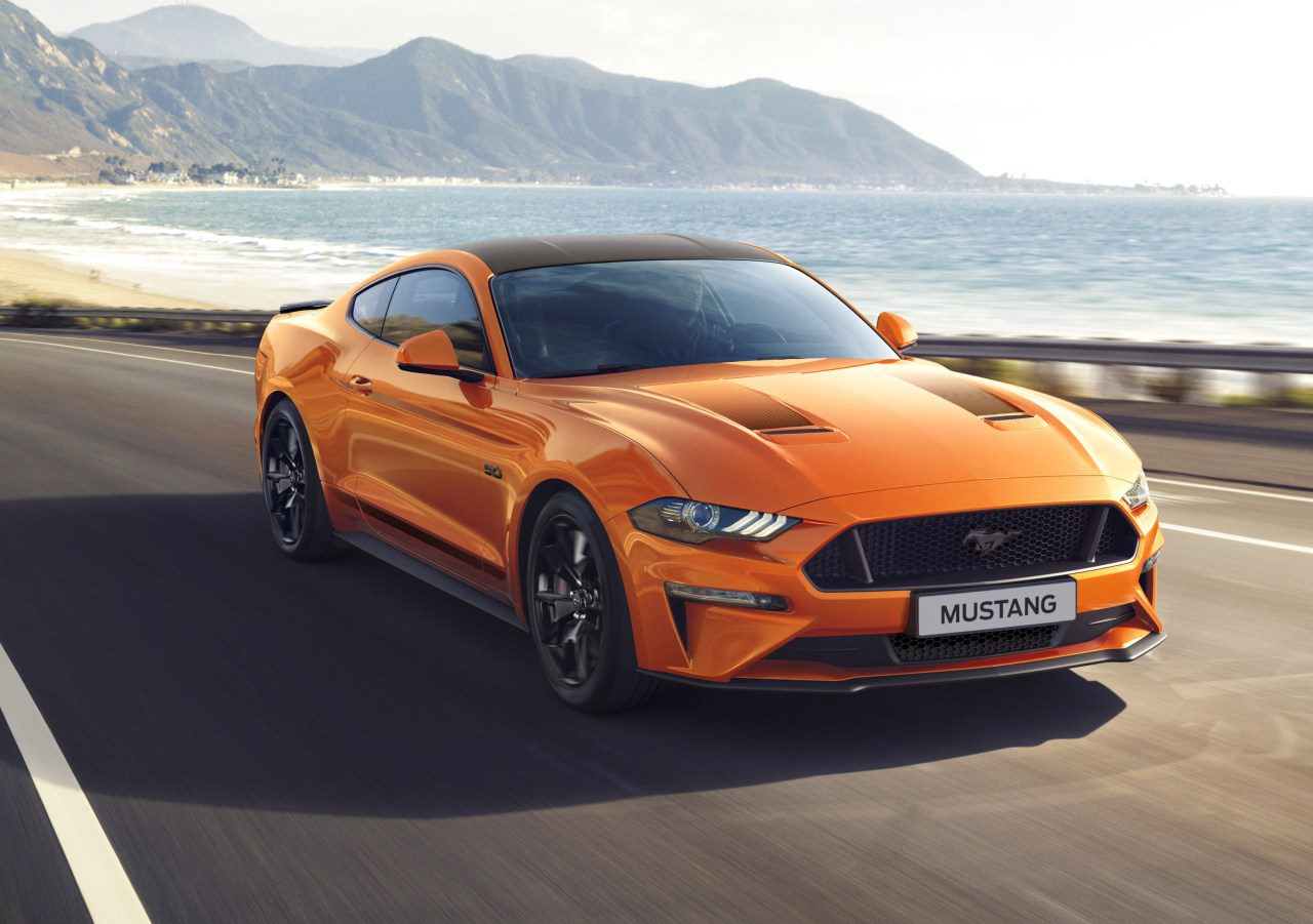 De Mustang uit 2019 rijdt op een weg vlakbij de oceaan.