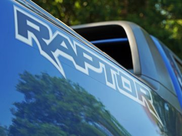 Een blauwe vrachtwagen met het woord "Raptor" op de zijkant, te zien in Fast & Furious: Hobbs & Shaw.