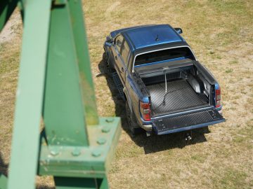 Een blauwe pick-up met open laadbak op een grasveld, dat doet denken aan een scène uit Fast & Furious: Hobbs & Shaw.