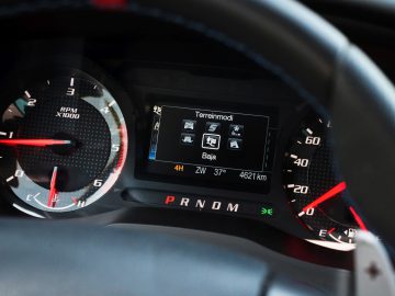 Het dashboard van een auto, dat doet denken aan 'Fast & Furious: Hobbs & Shaw', met rode en blauwe meters.