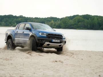De blauwe Ford Ranger, die doet denken aan de Fast & Furious: Hobbs & Shaw-stijl, rijdt door het zand.