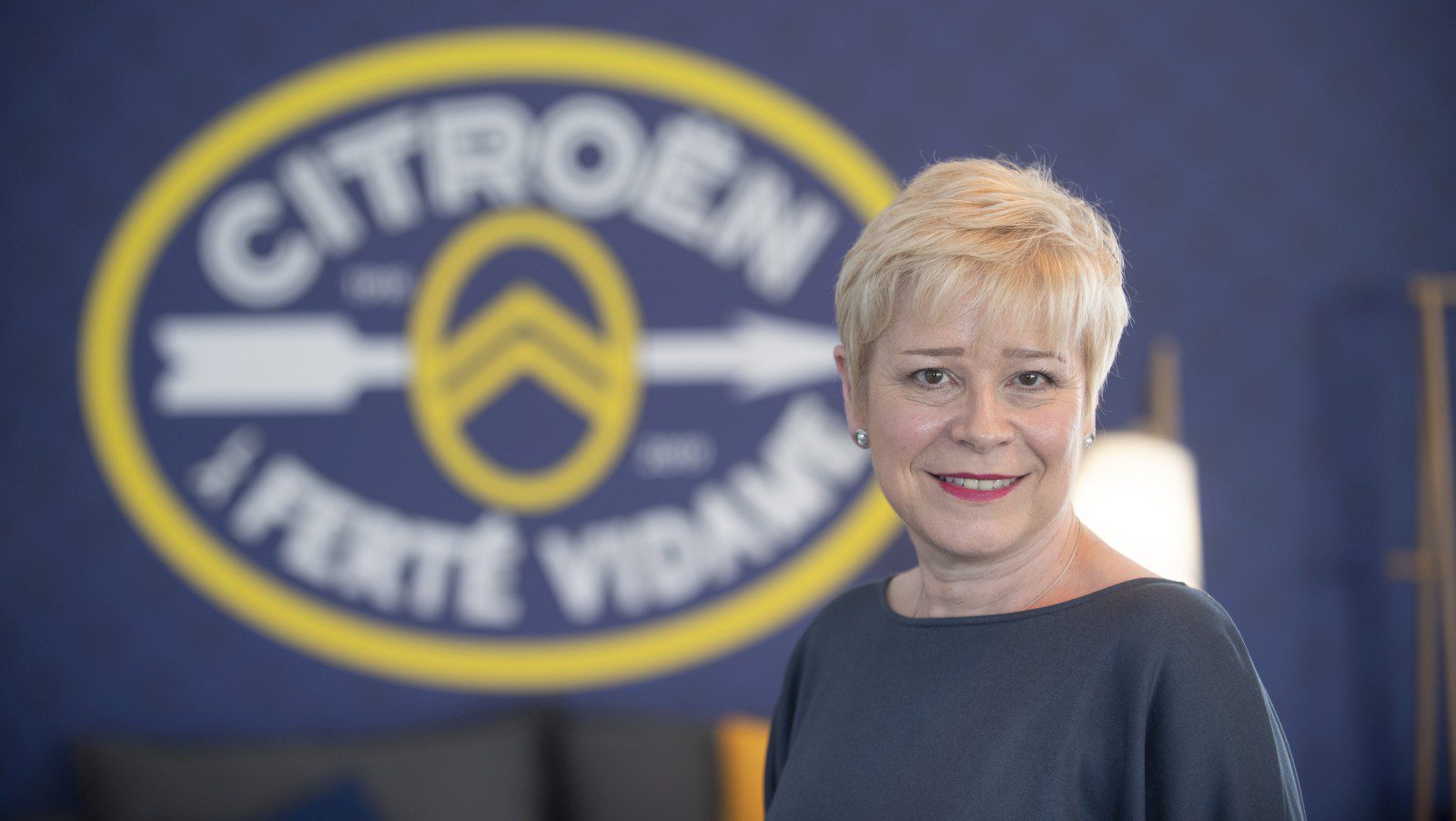 Een vrouw die voor een Citroën-logo staat.