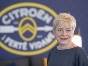 Een vrouw die voor een Citroën-logo staat.
