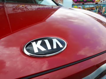 Kia Stonic-logo op de motorkap van een rode auto.