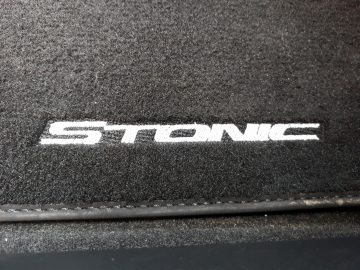 Kia Stonic-logo op de vloermat van een auto.
