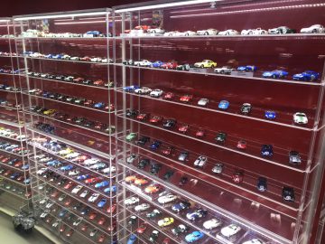 Een vitrine vol Le Mans-speelgoedauto's in een winkel.