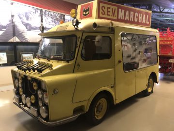 Een gele Le Mans-ijswagen staat tentoongesteld in een museum.