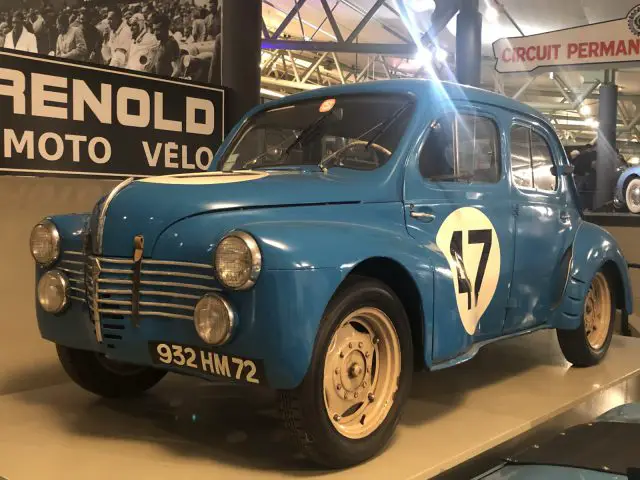 Een oude blauwe Le Mans-auto staat tentoongesteld in een museum.