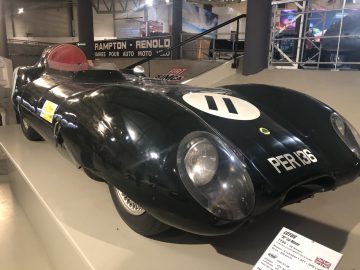 In een museum staat een zwarte Le Mans-raceauto tentoongesteld.