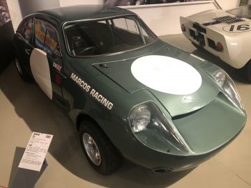 Een groene Le Mans-raceauto staat tentoongesteld in een museum.