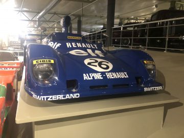 Een blauwe Le Mans-raceauto staat tentoongesteld in een museum.