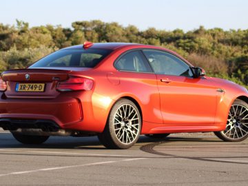 De BMW M2 Competition coupé staat geparkeerd op een parkeerplaats.