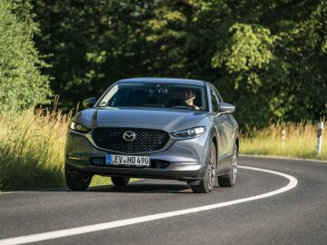 De Mazda 3 uit 2019 rijdt over een landweg.
