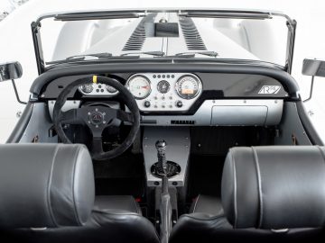 Het interieur van een Morgan Plus 4 sportwagen met lederen stoelen en stuurwiel.