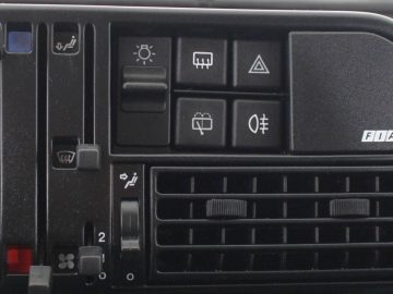 Het dashboard van een auto met een Panda-radio en knoppen.
