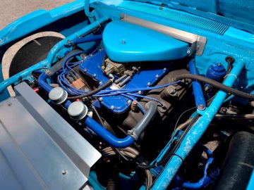 Het gesluierde motorcompartiment van een blauwe auto.